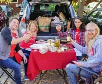 Group tailgating with table spread of food