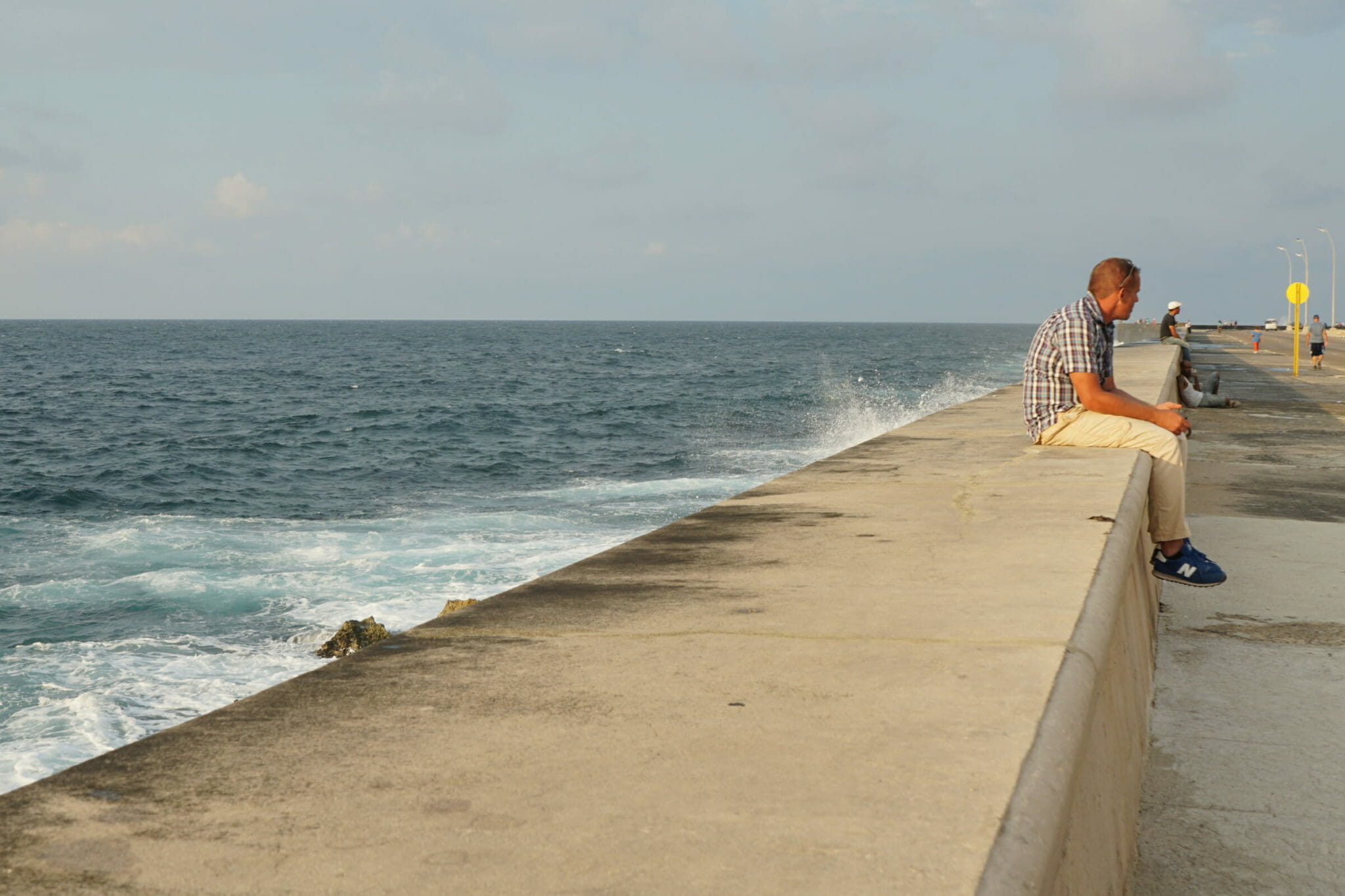 Man sitting by ocean's edge