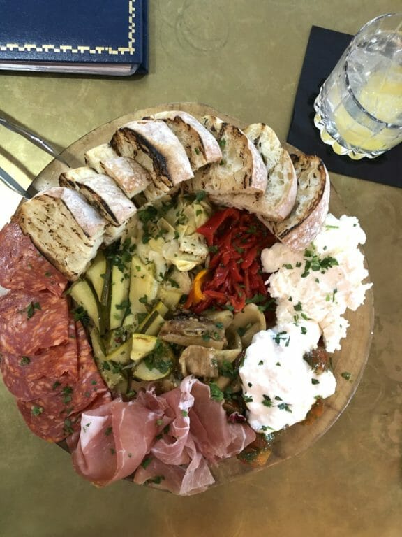 An appetizer plate from Bar Corallioni with marinated vagetables, cheese and fresh bread.