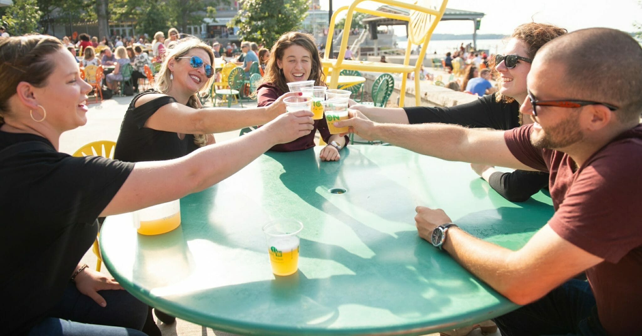 Guests toasting cups of beer on food and drink tour at Memorial Union in Downtown Madison, Wisconsin