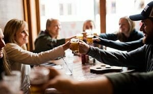 Guests toasting glasses of craft beer from Around the Square food and drink tour