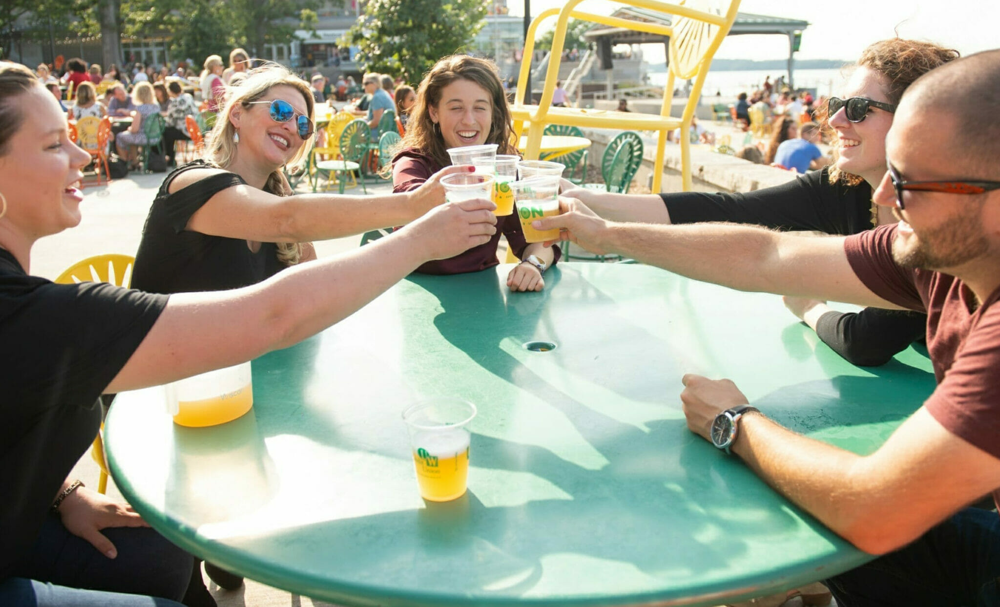 Guests toasting cups of beer on food and drink tour at Memorial Union in Downtown Madison, Wisconsin