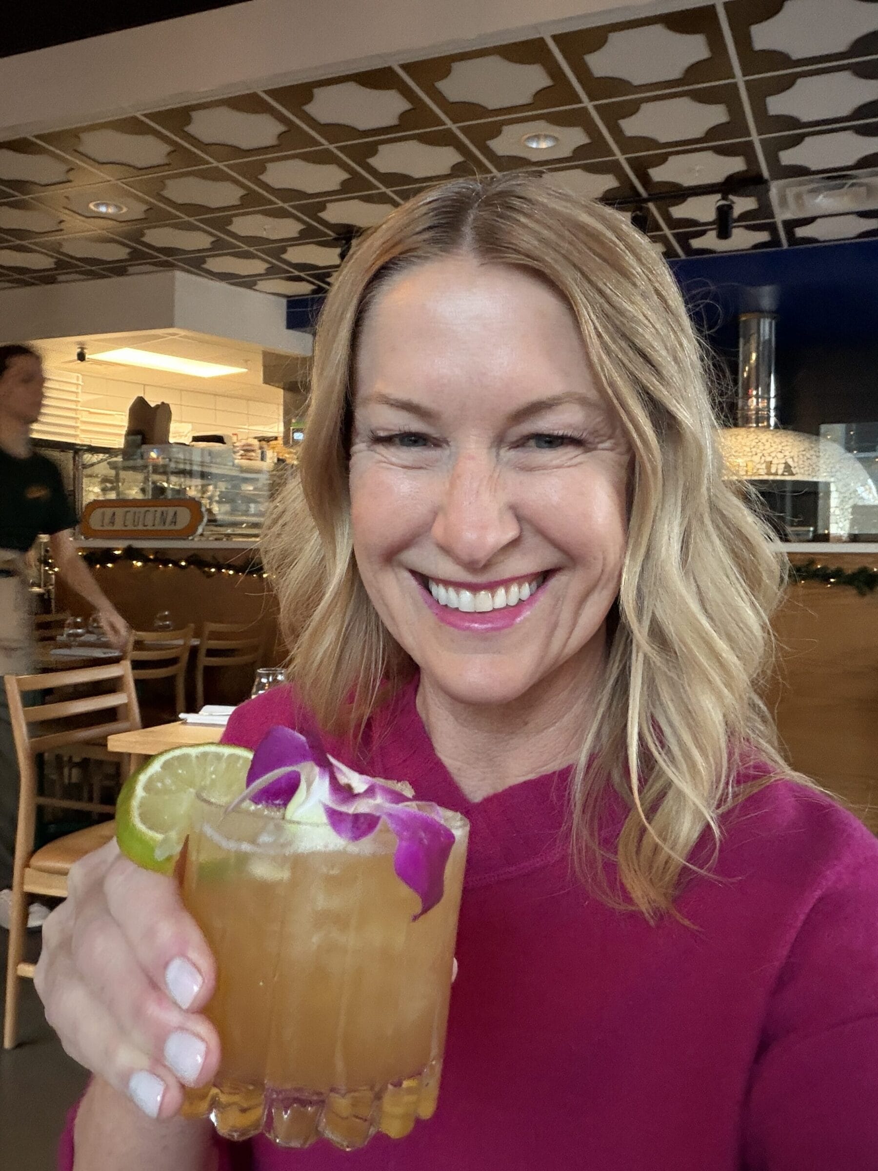 Madison eats Food Tours owner Otehlia holding a cocktail with flower decoration