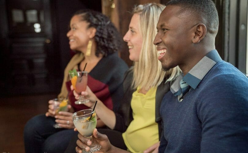 Guests smiling and holding cocktails in hand