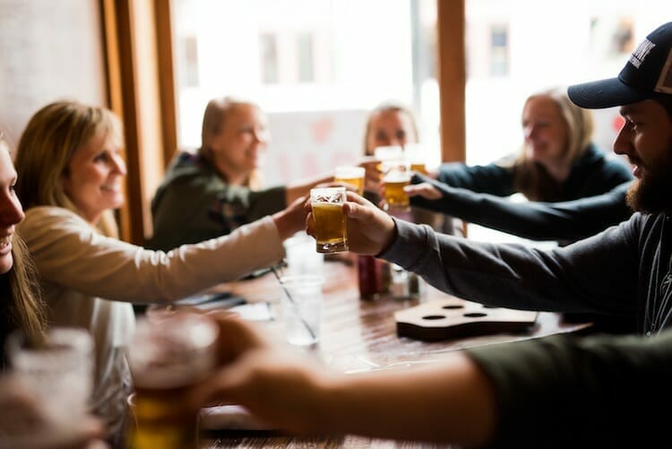 Guests toasting glasses of craft beer on Around the Square food and drink tour